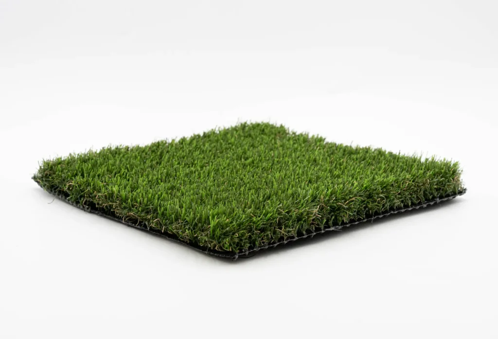 Angled square sample of dense green nylon artificial turf on white background
