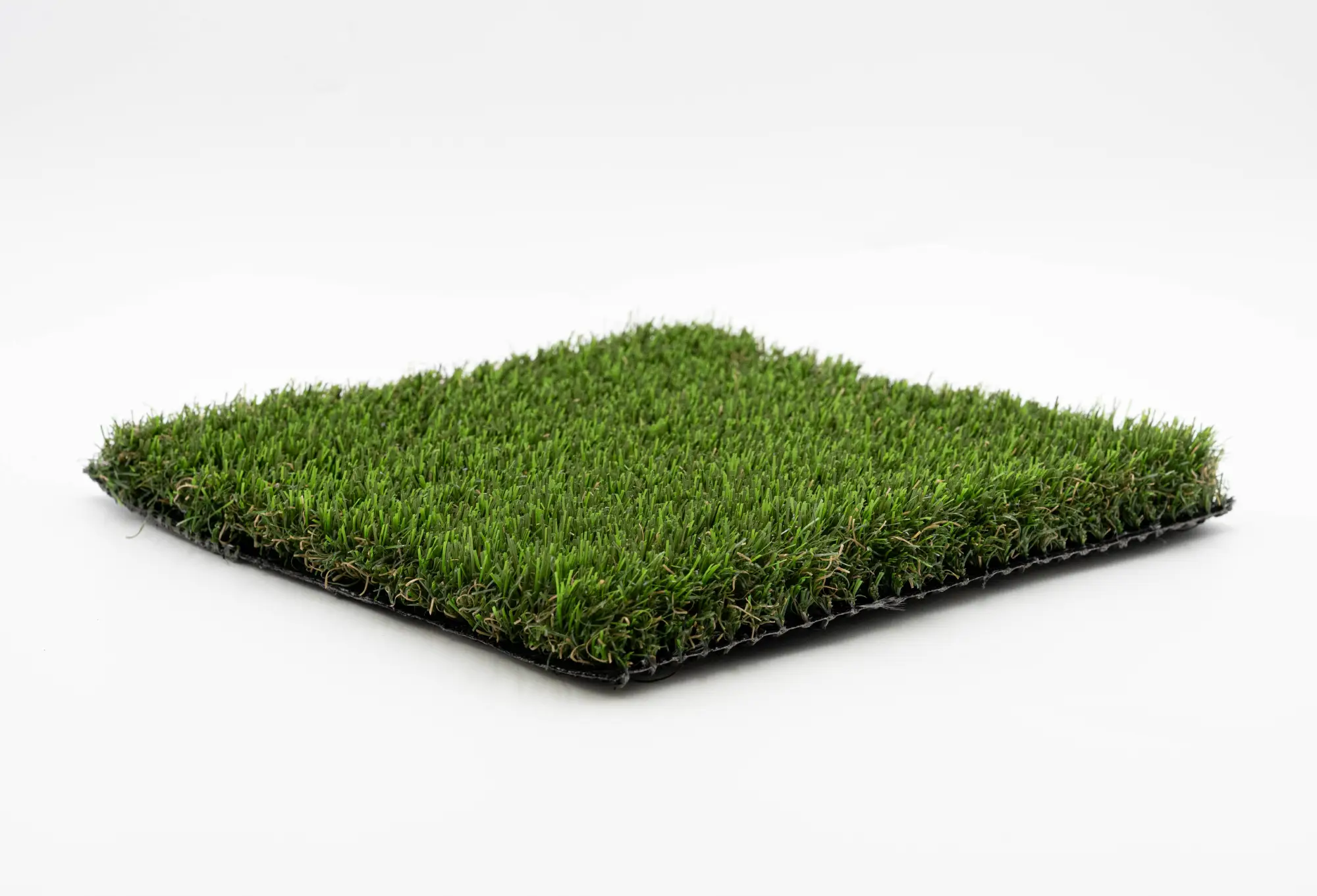 Angled square sample of dense green nylon artificial turf on white background